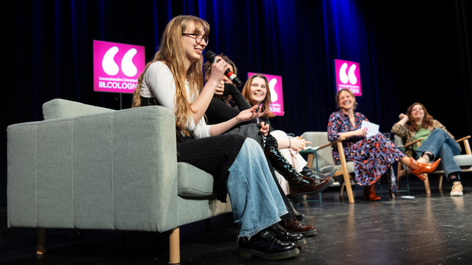 Fünf Frauen auf einer Bühne, die auf Sesseln sitzen. Drei der Frauen sind Teilnehmerinnen des OffSpring Awards.